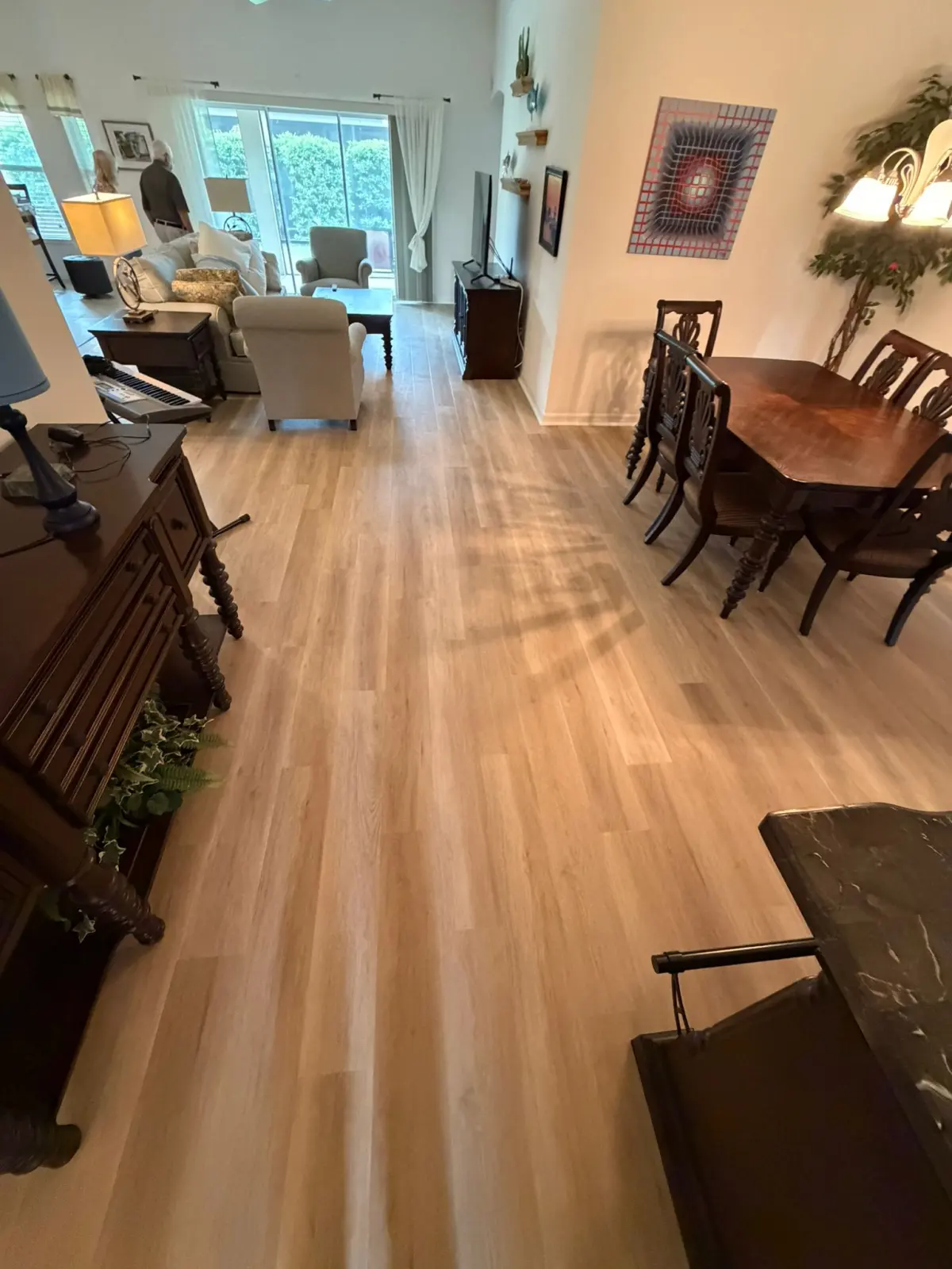 Dining and living area in light oak-look flooring in a Summerfield, FL home