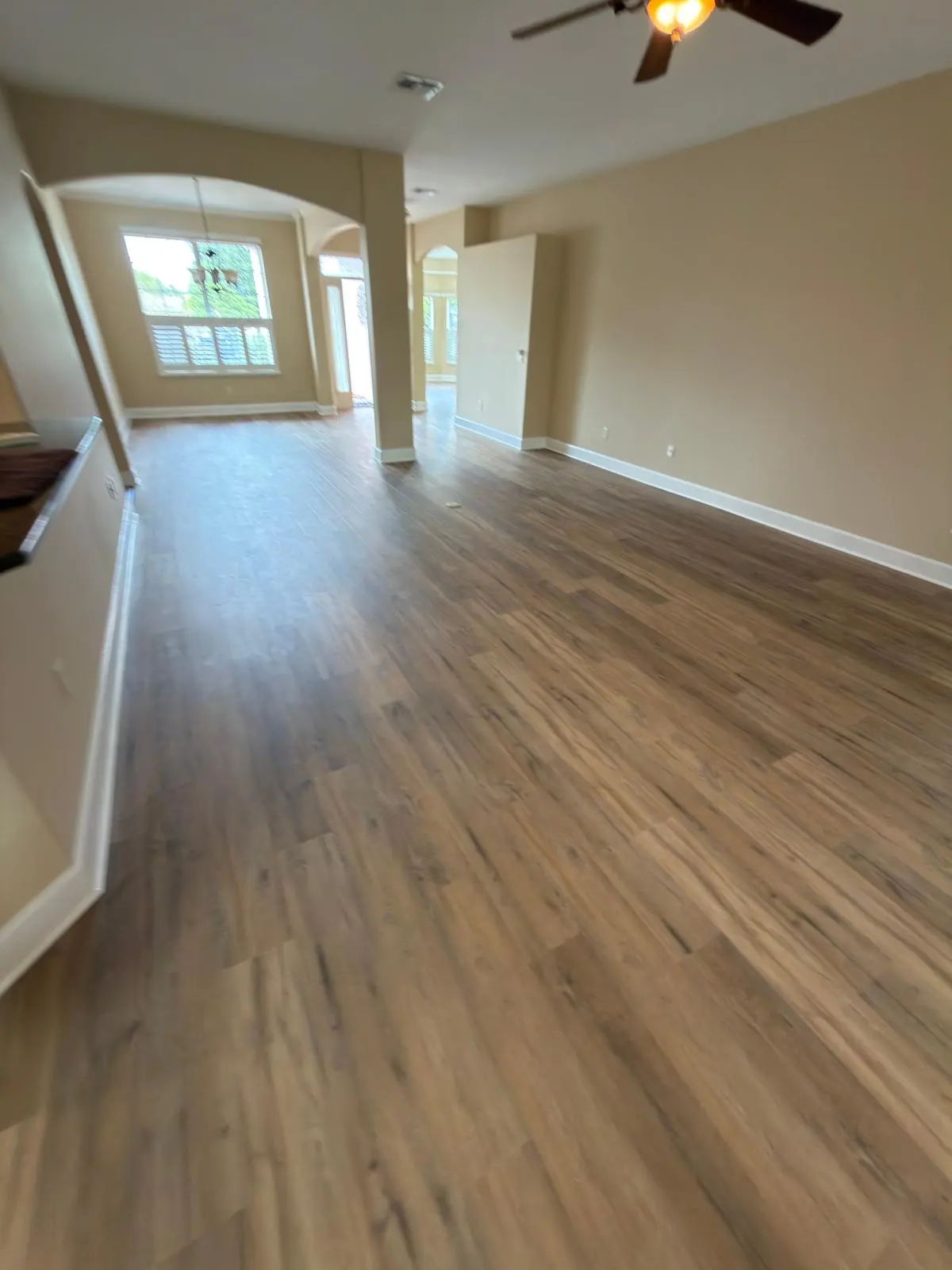 Wide wood-look vinyl plank running the length of an open living area in a Summerfield, FL home, showing plank size and surface grain