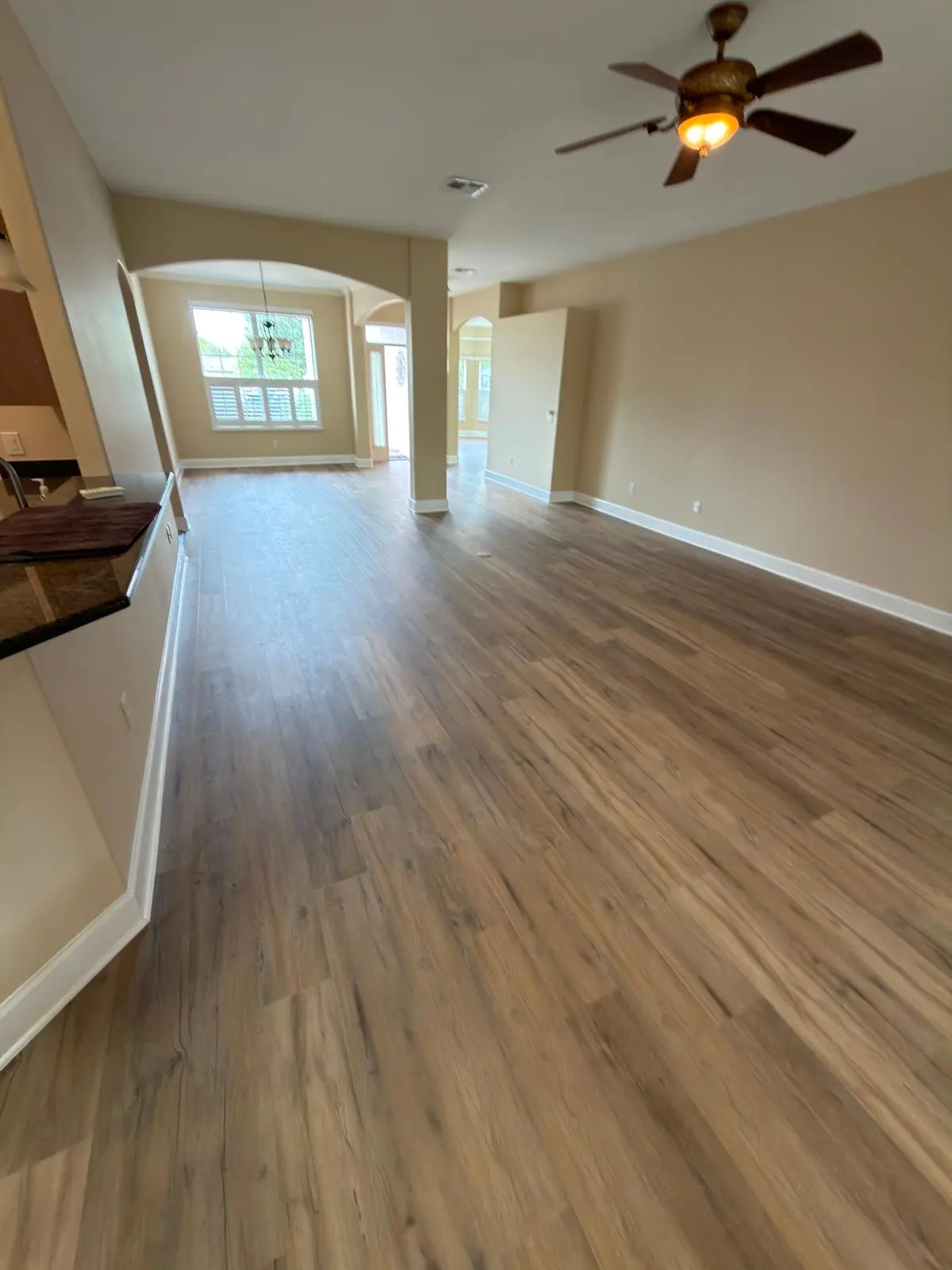 Open living area with ceiling fan and wide-plank flooring in a Summerfield, FL home