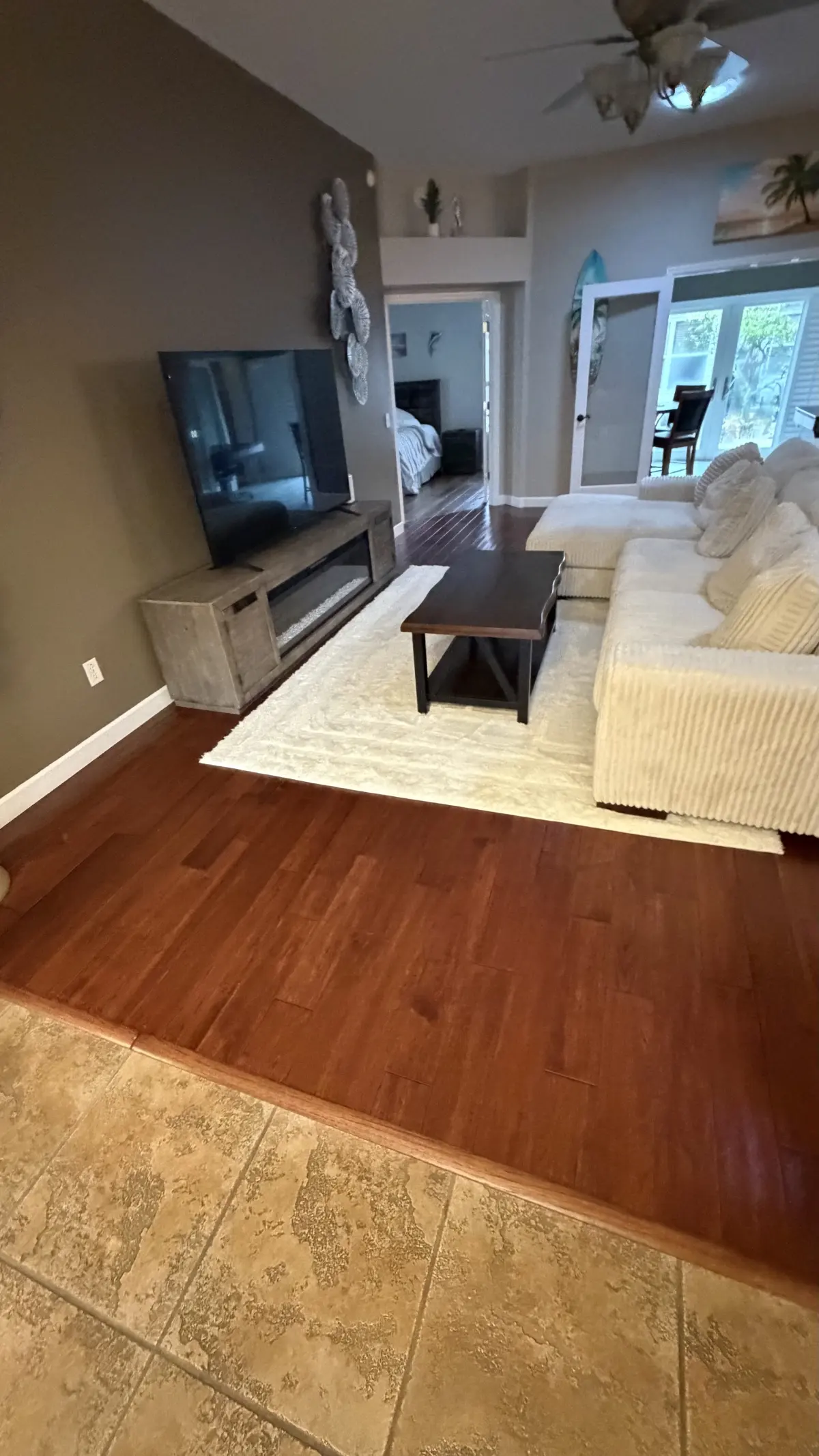 Wood-look plank flooring in the living room meeting tile at the entry of a Summerfield, FL home