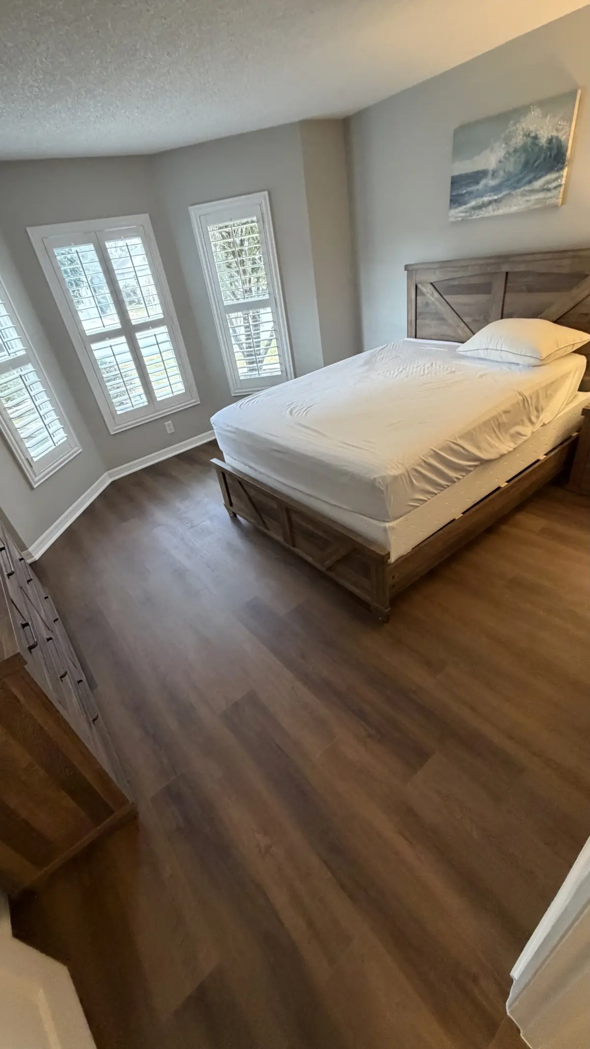 Bedroom with plantation shutters and wood-look plank in a Summerfield, FL home