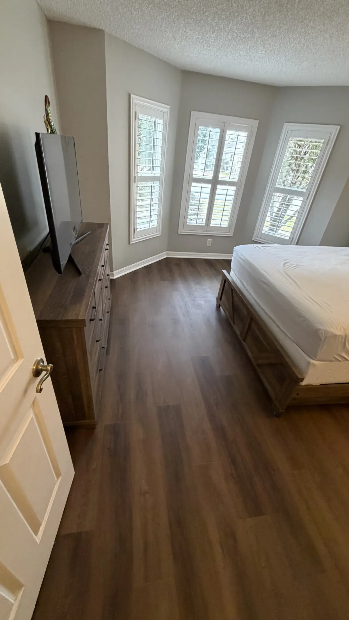 Bedroom in medium wood-look luxury vinyl plank in a Summerfield, FL home