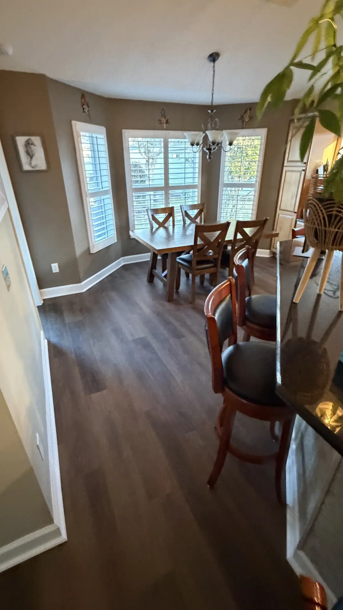 Dining room in medium wood-look plank flooring in a Summerfield, FL home
