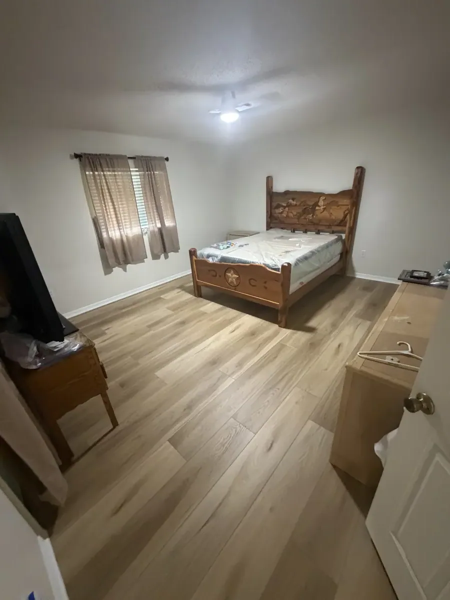 Bedroom in light gray wood-look luxury vinyl plank in a Summerfield, FL home
