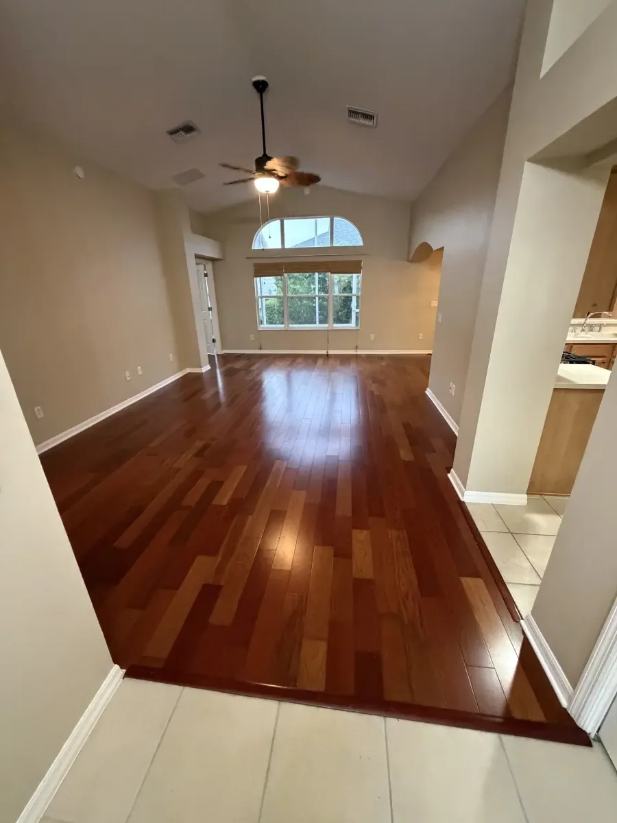 Entry and living room in glossy cherry-toned wood flooring in a Summerfield, FL home
