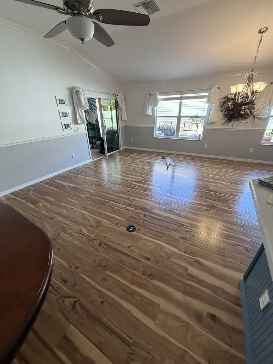 Living room in warm wood-look flooring in a Summerfield, FL home