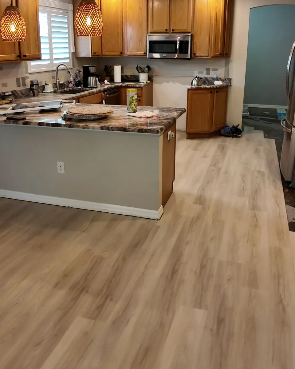The same kitchen with new light wood-look luxury vinyl plank installed